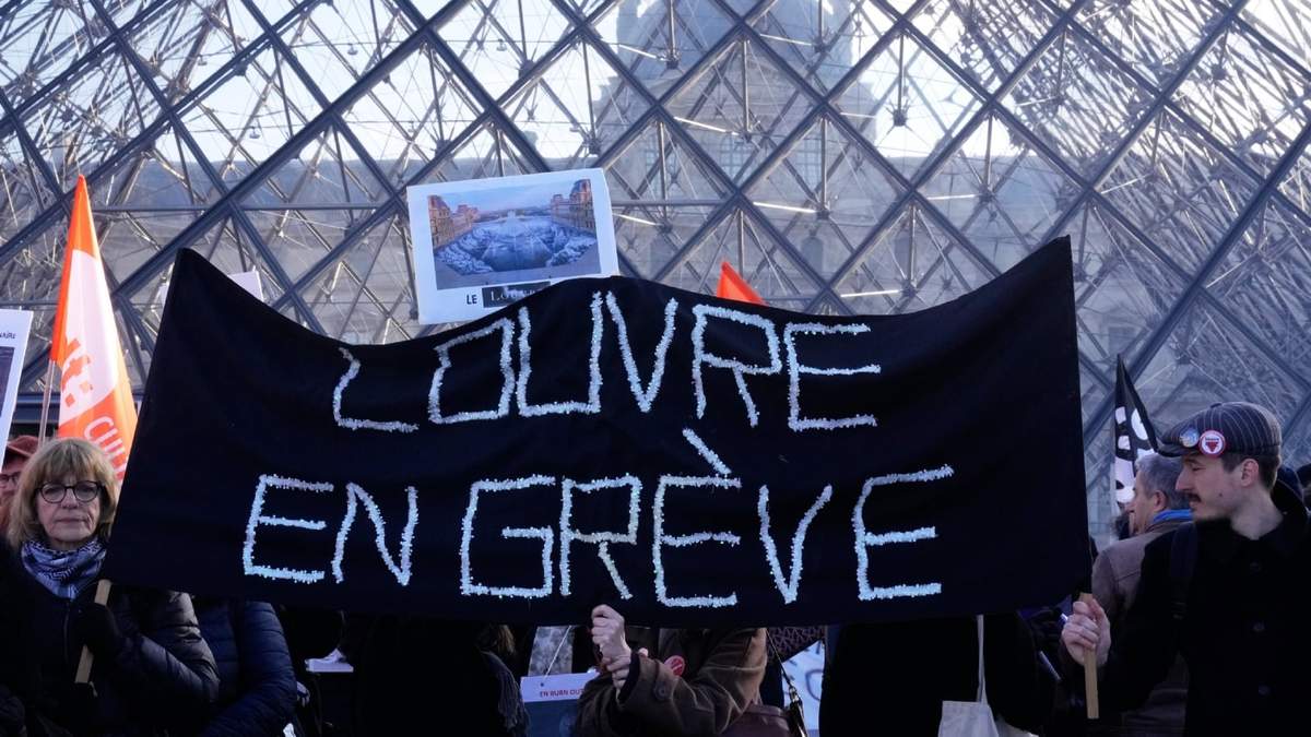 Trabajadores despliegan una pancarta con la frase (en francés) "Louvre en huelga", en el exterior del museo del Louvre tras votar a favor de continuar con la protesta en favor de la mejora de las condiciones laborales, entre otras quejas, el 15 de diciembre de 2025, en París