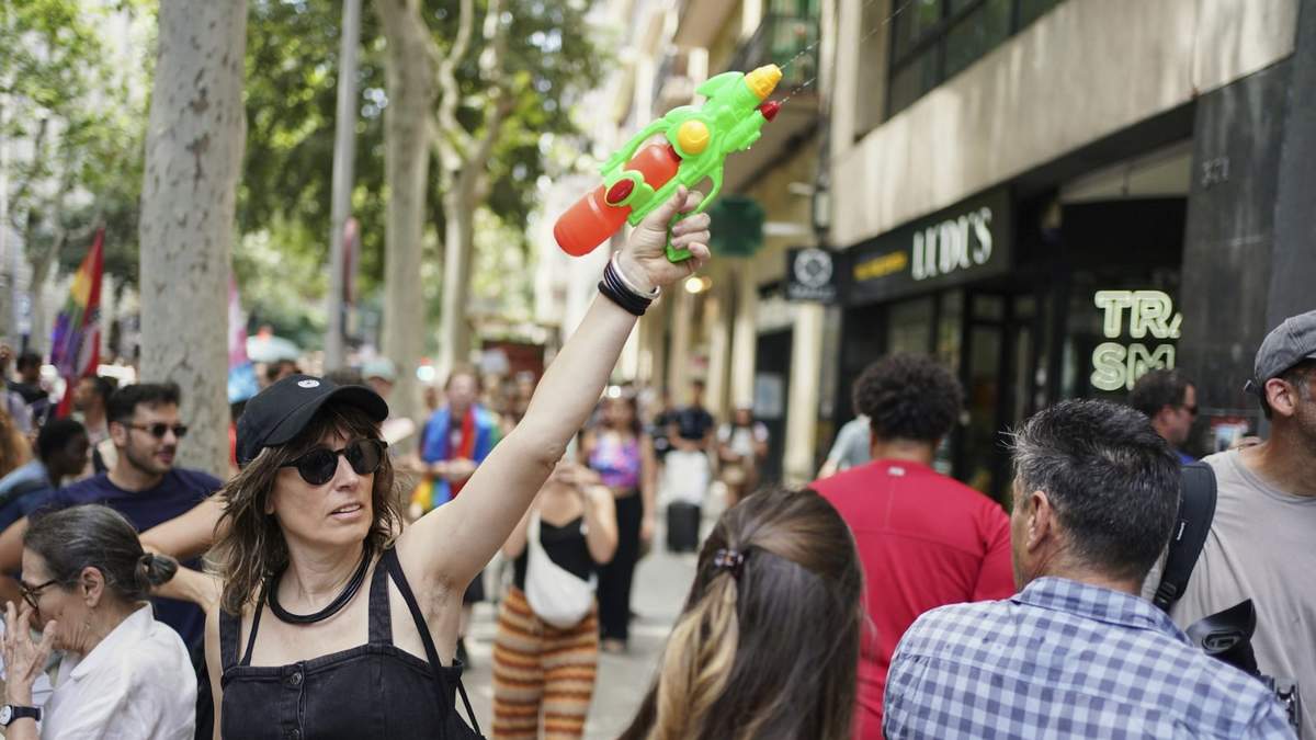 Una manifestante con una pistola de agua participa en una protesta contra el turismo excesivo, este domingo en Barcelona.