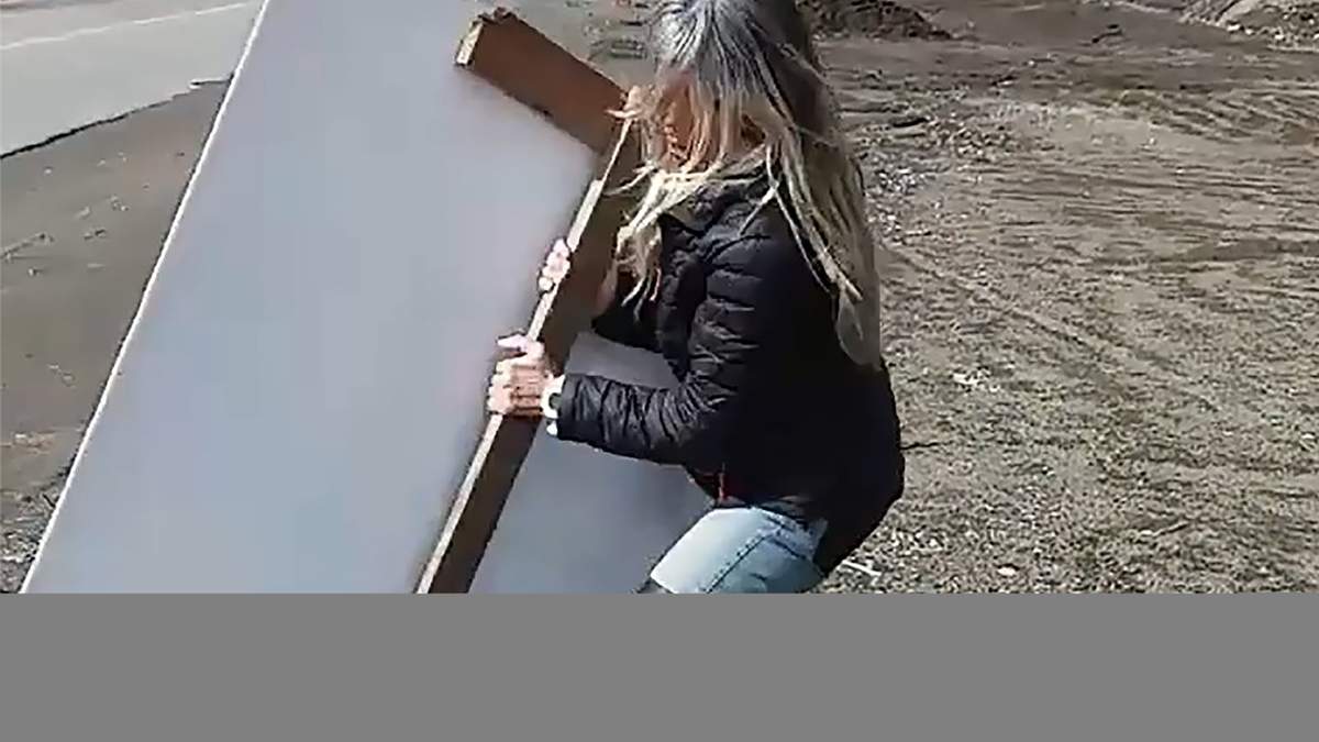 Vecina retira cartelería política de la vía pública. Fuente: (Minuto Neuquén)