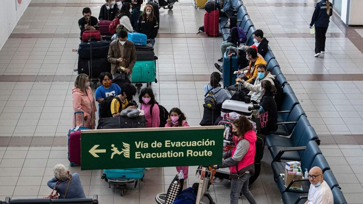 Extranjeros recién llegados a Chile esperan su traslado a un hotel, donde deben pasar 5 días en cuarentena