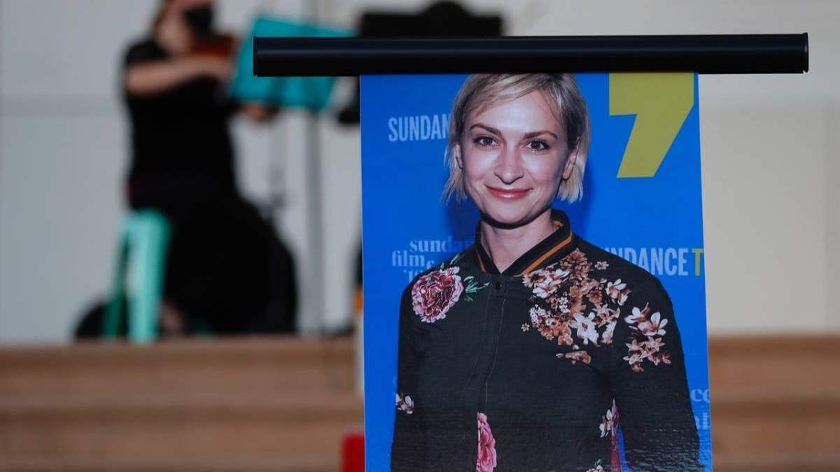 Un músico toca un violín detrás de una imagen de la directora de fotografía Halyna Hutchins durante una ceremonia en su honor