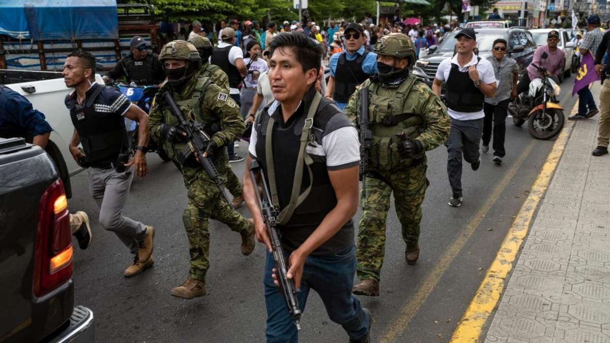 Soldados y policías avanzan detrás de un vehículo blindado mientras seguidores del candidato presidencial Daniel Noboa asisten a un acto político con el aspirante en la ciudad de Esmeraldas, Ecuador
