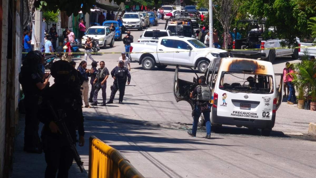Policías resguardan la escena donde una urvan de transporte público fue incendiada esta mañana en Chilpancingo y que dejó como saldo dos mujeres y dos niñas con quemaduras
