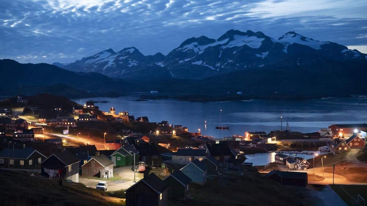 ARCHIVOS - Viviendas iluminadas tras el anochecer en Tasiilaq, Groenlandia, el viernes 16 de agosto de 2019. Un grupo de mujeres indígenas en Groenlandia ha demandado a Dinamarca por obligarlas a que se les implantaran dispositivos intrauterinos anticonceptivos en las décadas de 1960 y 1970, y exigieron una compensación total de casi 43 millones de coronas
