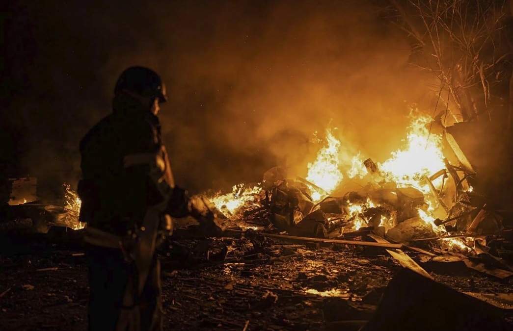 En esta imagen proporcionada por el Ministerio ucraniano de Situaciones de Emergencia, bomberos apagan un incendio provocado por restos de un cohete ruso que había sido derribado por defensas antiaéreas, durante un ataque ruso en Kiev