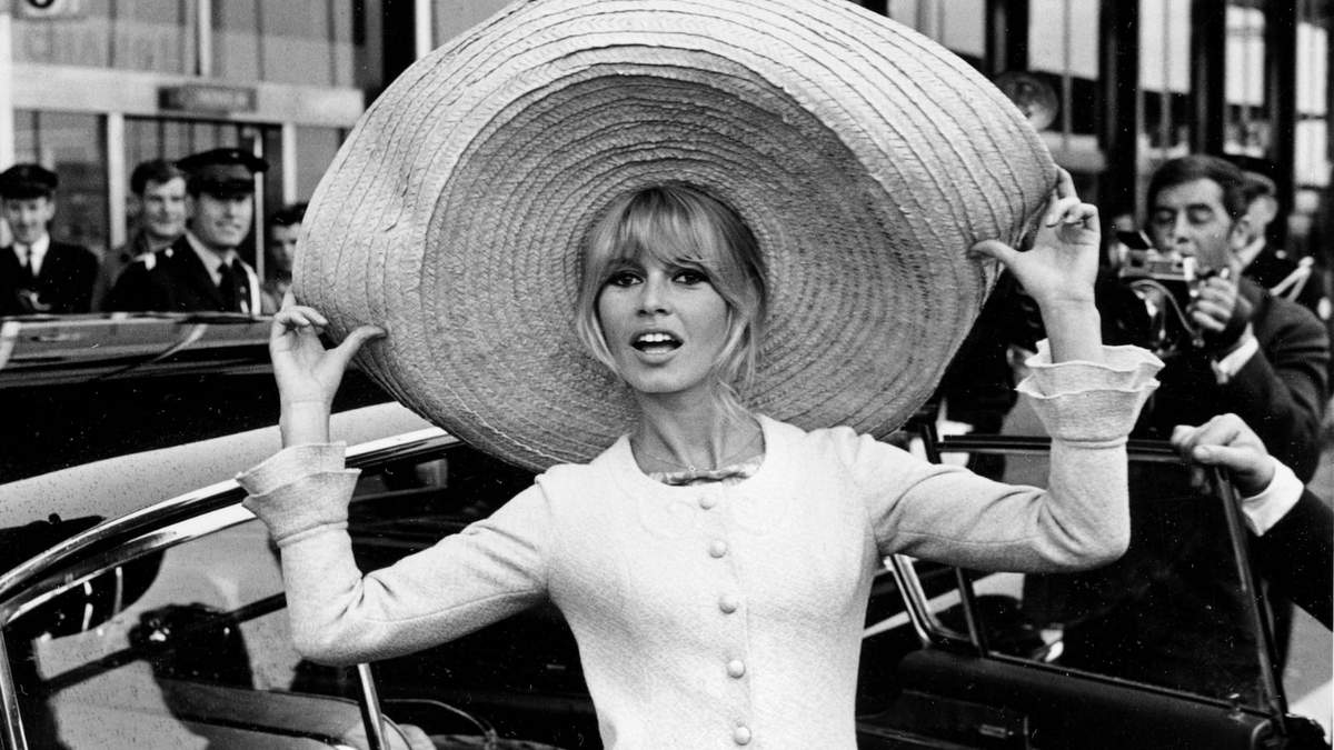 La actriz francesa Brigitte Bardot posa con un enorme sombrero que trajo de México, a su llegada al aeropuerto de Orly, el 27 de mayo de 1965
