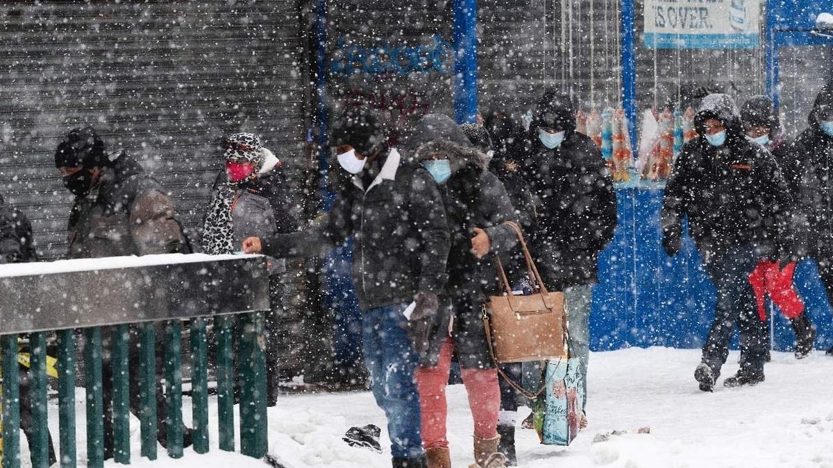La gente en una tormenta de nieve en el barrio del Bronx de NY