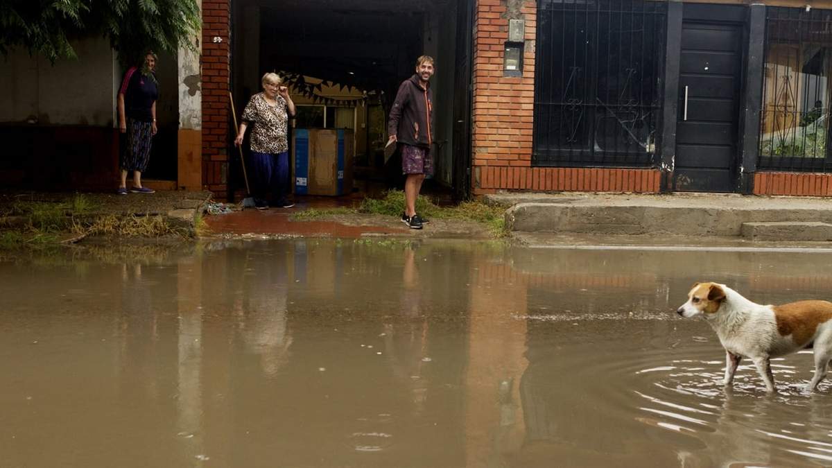 Vecinos intentan secar el agua que ingresó en sus casas sobre la calle Vicente López y Planas. Fuente: (Emiliano Ortiz)