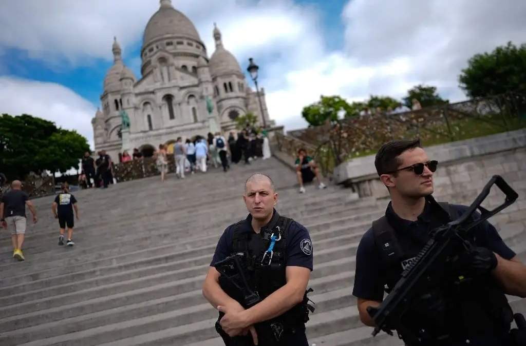 Oficiales de la Fuerza de Intervención de la Policía Nacional vigilan la basílica del Sagrado Corazón de Montmartre, antes de los Juegos Olímpicos de Verano de 2024, el 22 de julio de 2024, en París