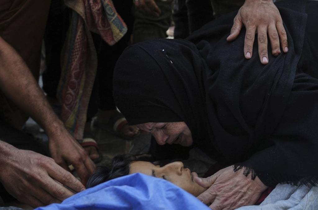 Familiares lloran el cuerpo de Seraje Ebrahim, de 13 años, quien murió en un ataque israelí dirigido contra un punto de distribución de agua potable, en el Hospital Al-Awda en Nuseirat, en el centro de la Franja de Gaza, el domingo 13 de julio de 2025.