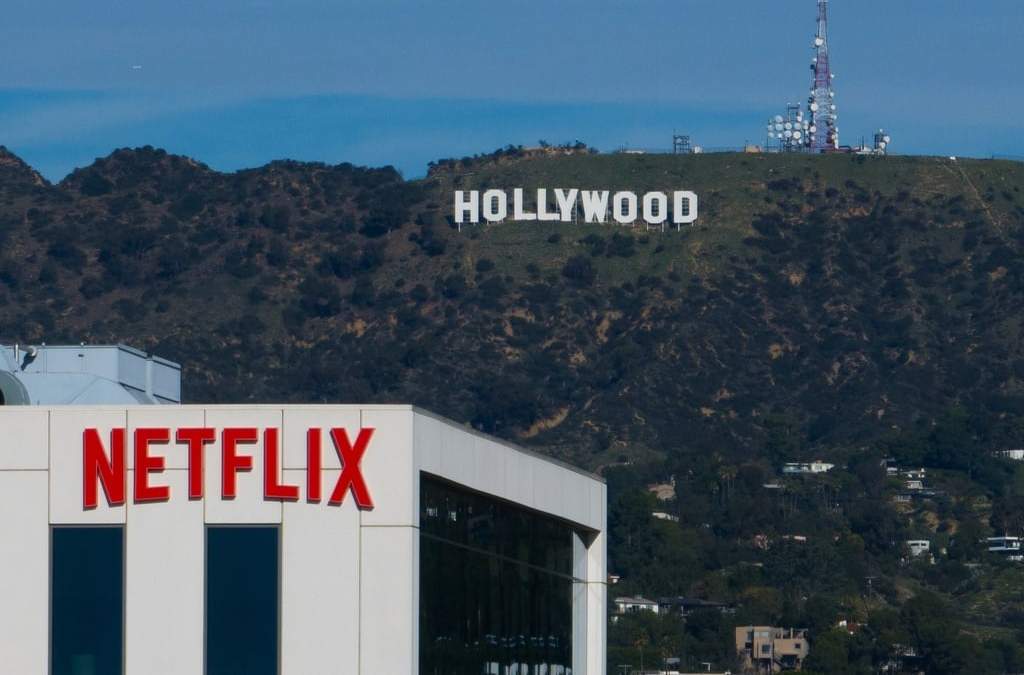 ARCHIVO - Un cartel de Netflix se muestra en lo alto de un edificio en Los Ángeles, el 18 de diciembre de 2025, con el cartel de Hollywood a la distancia