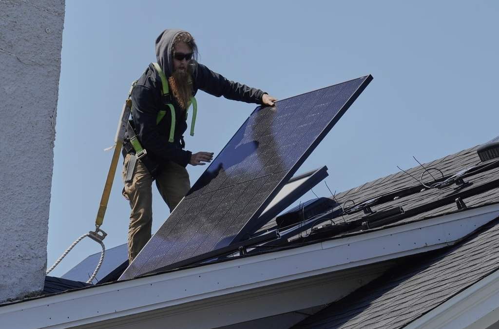 Theodore Tanczuk, de la empresa instaladora de energía solar YellowLite, coloca un panel en el techo de una casa en Lakewood, Ohio, 16 de abril del 2025
