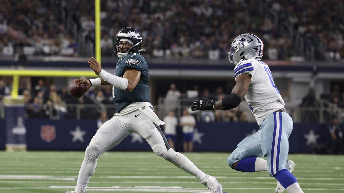 Jalen Hurts, quarterback de los Eagles de Filadelfia, busca lanzar el balón bajo la presión de linebacker Micah Parsons de los Cowboys