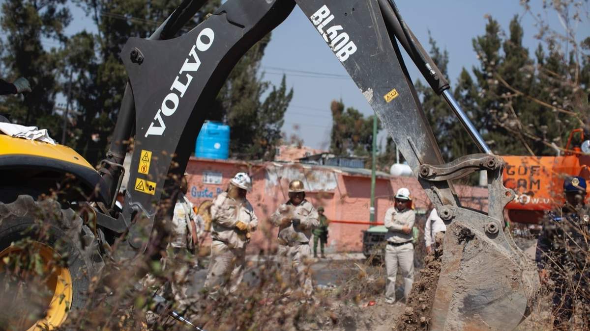 Trabajadores de Pemex excavan en el área donde se detectó una toma clandestina de combustible