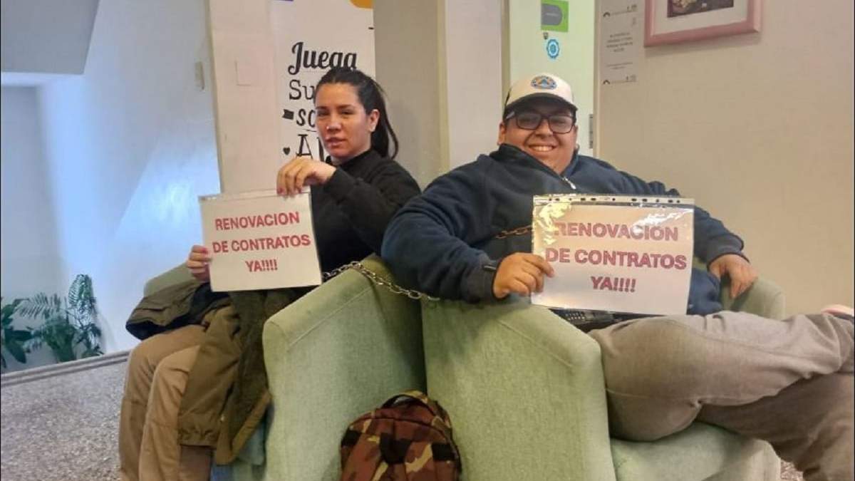 Los extrabajadores Emilia Jasín y Tomás González, encadenados en la entrada al municipio de Centenario. Fuente: (Noticias 7)
