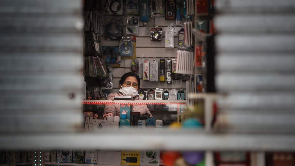 Local comercial con la persiana semiabierta como parte del protocolo sanitario. Fuente: (Twitter)