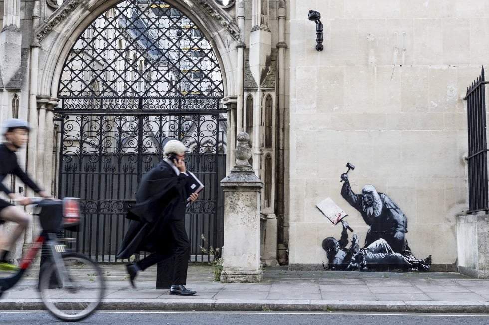Foto sin fecha publicada por Banksy de su nueva obra, que retrata a un juez golpeando a un manifestante con un mazo en los Tribunales Reales de Justicia de Londres. (