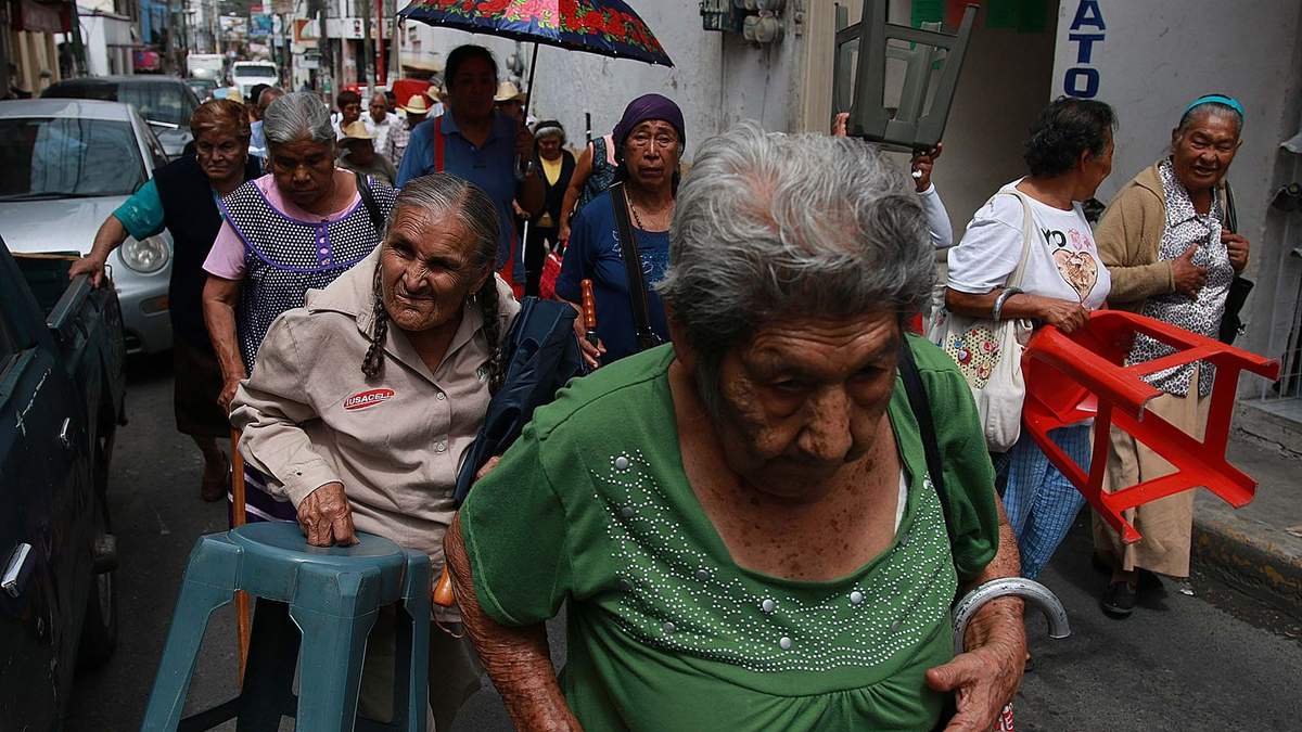 Personas de la tercera edad hacen fila para cobrar su pensión