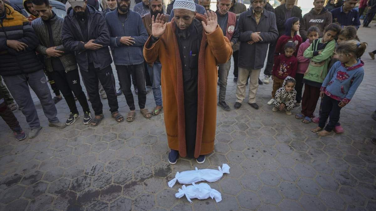El imán Islam Abu Suaied ora ante los cuerpos de dos bebés antes de su sepelio en el hospital Mártires de Al-Aqsa en Deir al-Balah, en el centro de la Franja de Gaza, el 29 de diciembre de 2024. Uno de los bebés murió al nacer, mientras que el otro, Jomaa al-Batran, de 20 días de nacido, sucumbió a la hipotermia. Según autoridades sanitarias locales, al menos otros tres bebés murieron de frío en Gaza en las últimas semanas