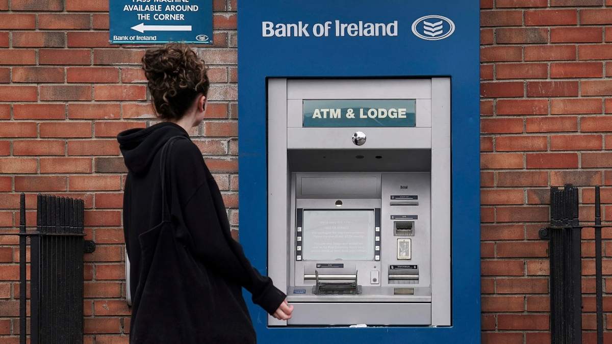 Una persona pasa frente a un cajero automático fuera de servicio del Bank of Ireland en Dublín