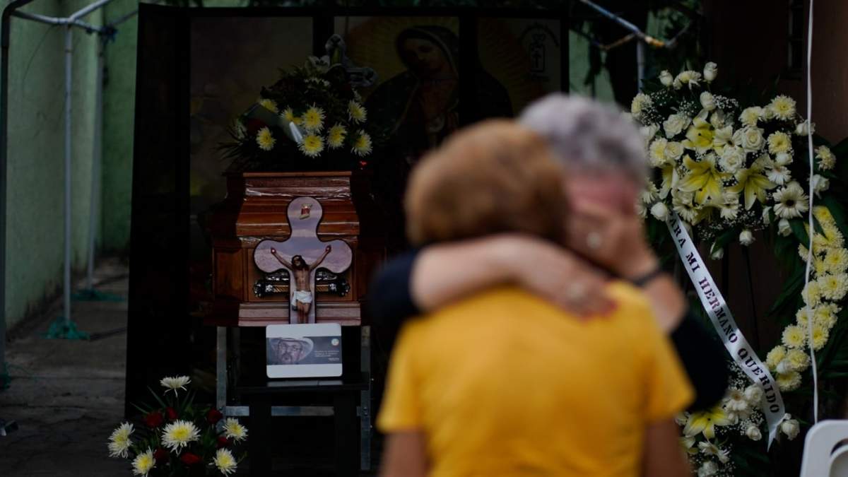 Familiares de Hipólito Mora se abrazan cerca de su féretro, en el velorio de este líder de las autodefensas civiles armadas en su casa de La Ruana