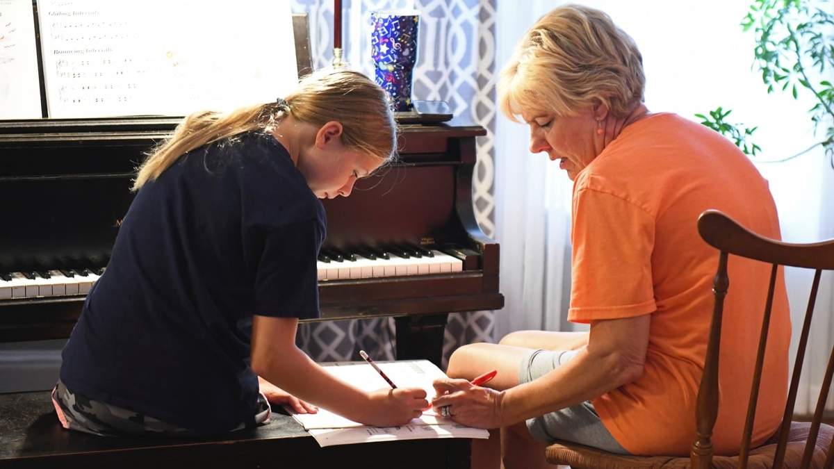 Keegan Pruente, izquierda, trabaja con Laura Kilpatrick, derecha, en una de sus clases de piano en Independence, Missouri