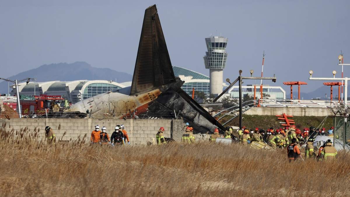 Bomberos y socorristas trabajan en el Aeropuerto Internacional de Muan, en Corea del Sur, el domingo 29 de diciembre de 2024, luego de que un avión comercial se salió de la pista de aterrizaje, chocó contra un muro de concreto y se incendió