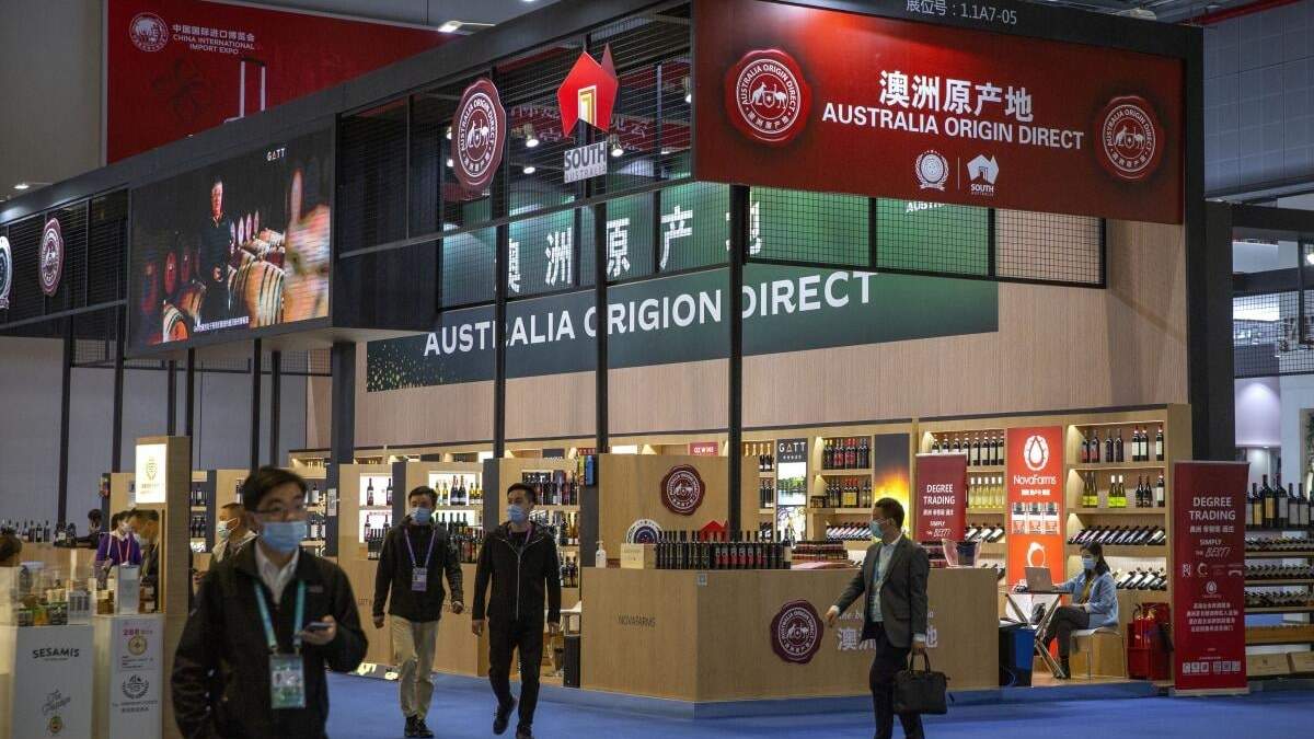 En esta imagen de archivo, visitantes pasan junto a un expositor de vinos australianos y otros productos agrícolas en la Exposición Internacional de Importación de China, en Shanghái, China