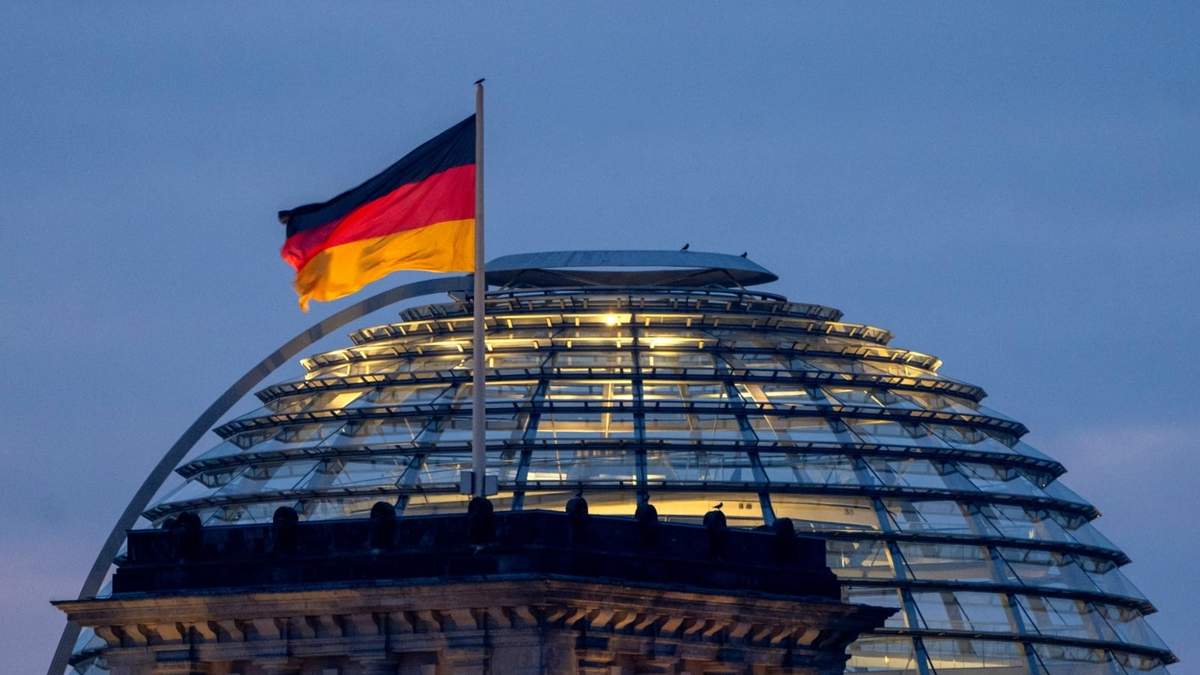 Una bandera alemana ondea sobre el edificio del Reichstag en Berlín, Alemania, el domingo 23 de febrero de 2025