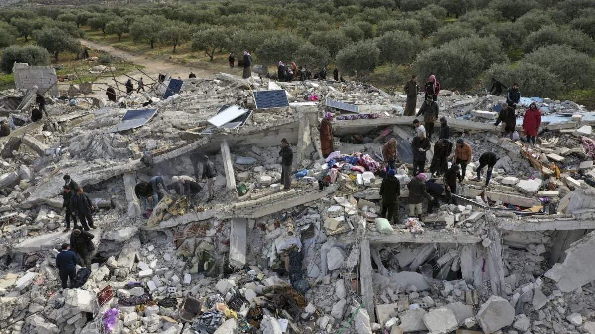 Socorristas y residentes buscan entre los escombros de los edificios derrumbados por un temblor en la ciudad de Harem, cerca de la frontera turca, provincia de Idlib