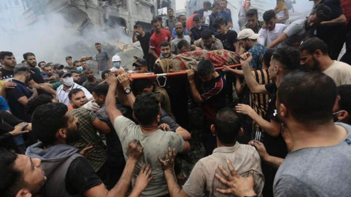 Palestinos retiran un cuerpo de entre los escombros de un edificio tras un ataque aéreo israelí al campo de refugiados Jebaliya, en la Franja de Gaza