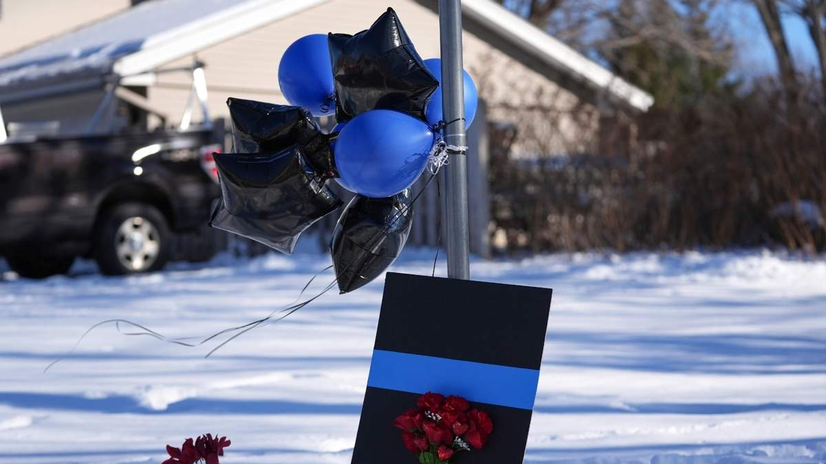 Un monumento conmemorativo improvisado se encuentra cerca del lugar donde dos policías y un socorrista fueron asesinados a tiros el domingo