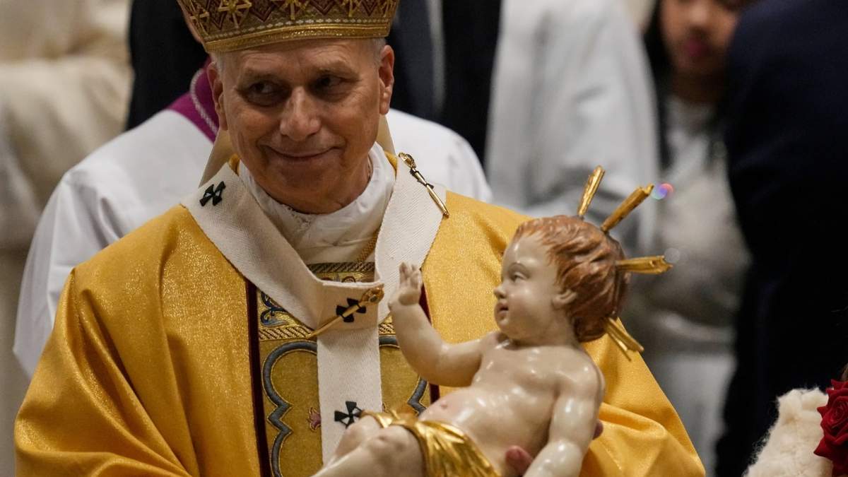 El papa León XIV carga una imagen del Niño Jesús durante la misa de Nochebuena