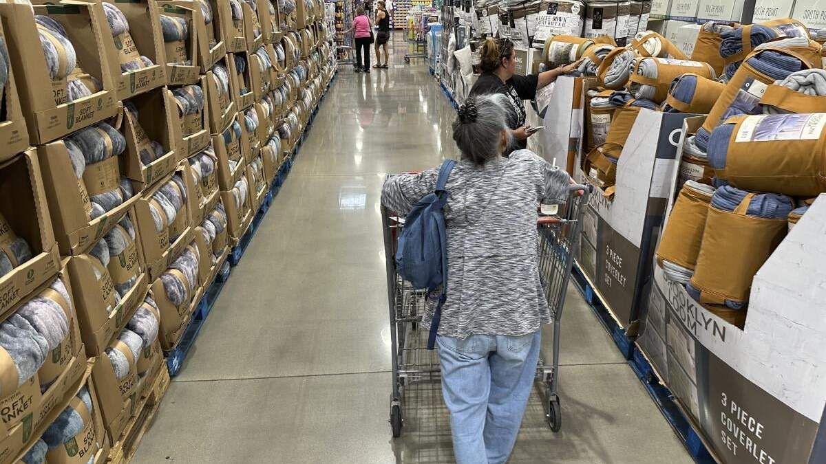 ARCHIVO - Consumidores ven los precios de cobijas a la venta en una tienda de la cadena Costco, el 24 de agosto de 2023, en Sheridan, Colorado. (AP Foto/David Zalubowski, archivo)
