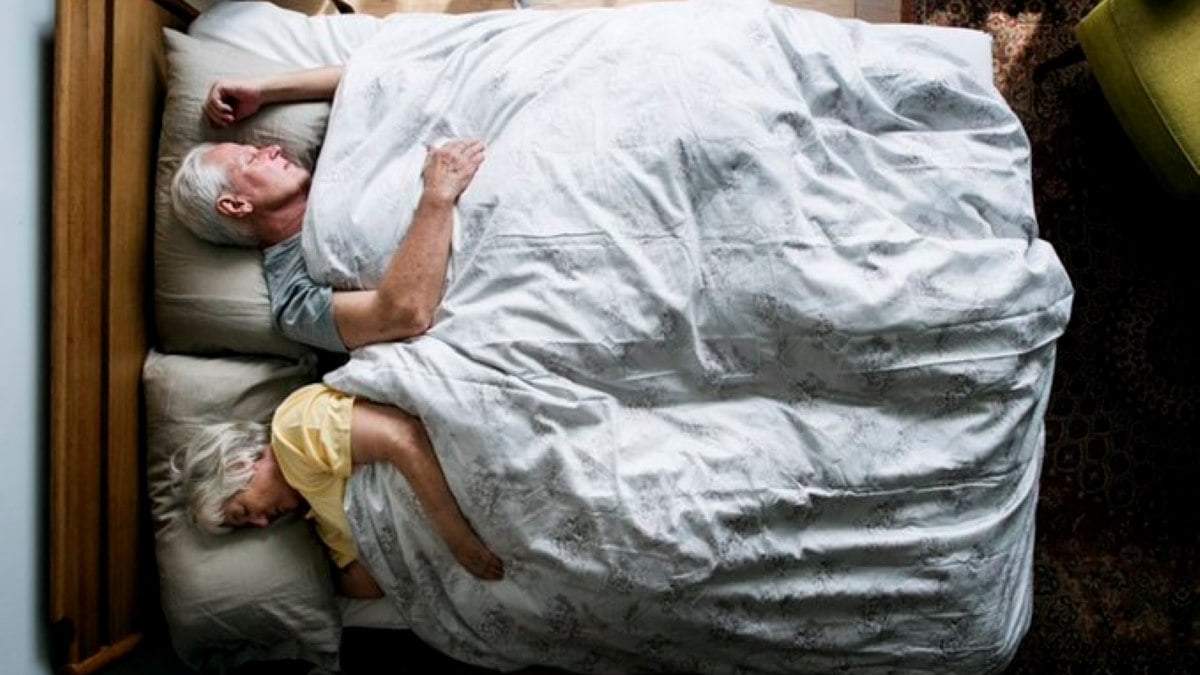 Pareja durmiendo en la cama.