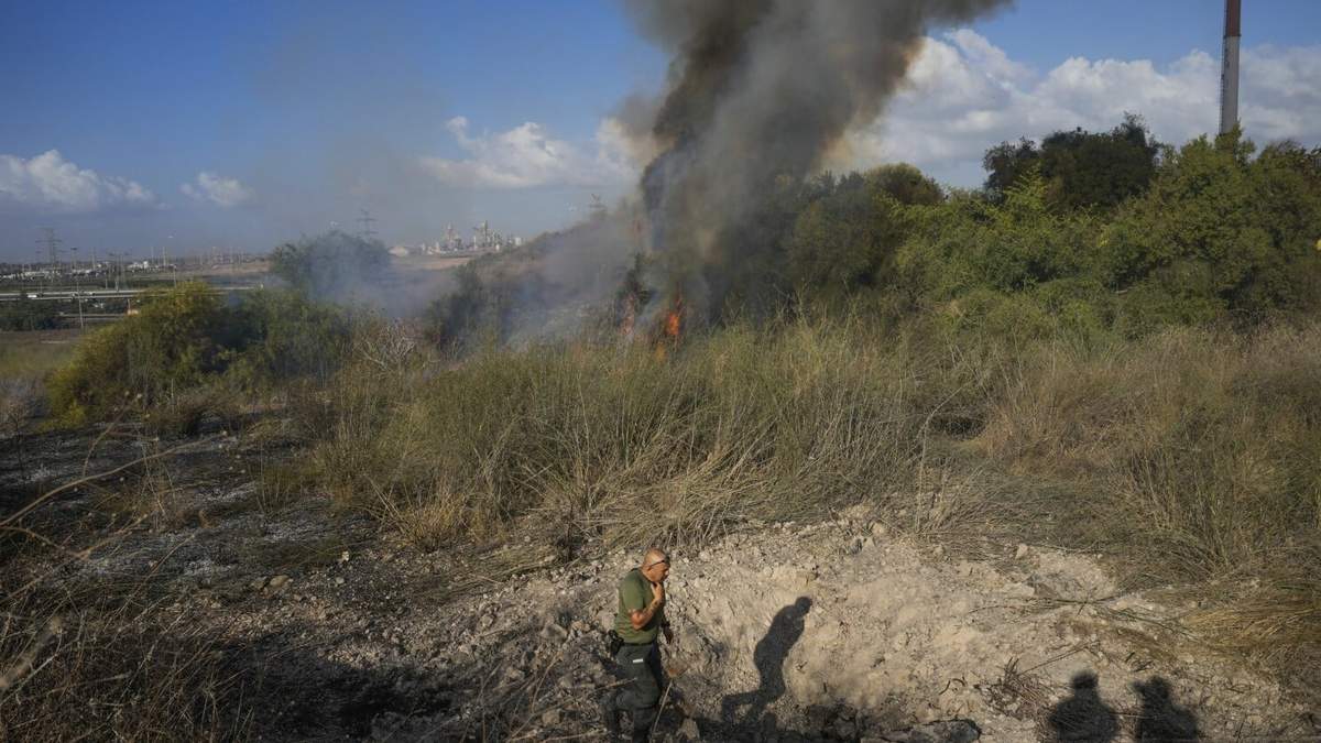 Un agente de policía inspecciona la zona en torno a un incendio después de que el ejército dijera haber lanzado proyectiles para interceptar un misil lanzado desde Yemen que aterrizó en el centro de Israel