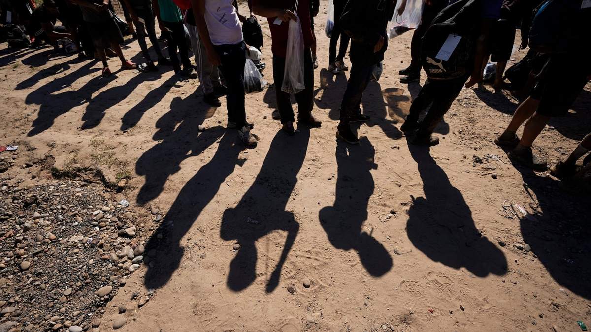 Migrantes esperan a ser procesados por la Patrulla Fronteriza de Estados Unidos después de cruzar el río Bravo