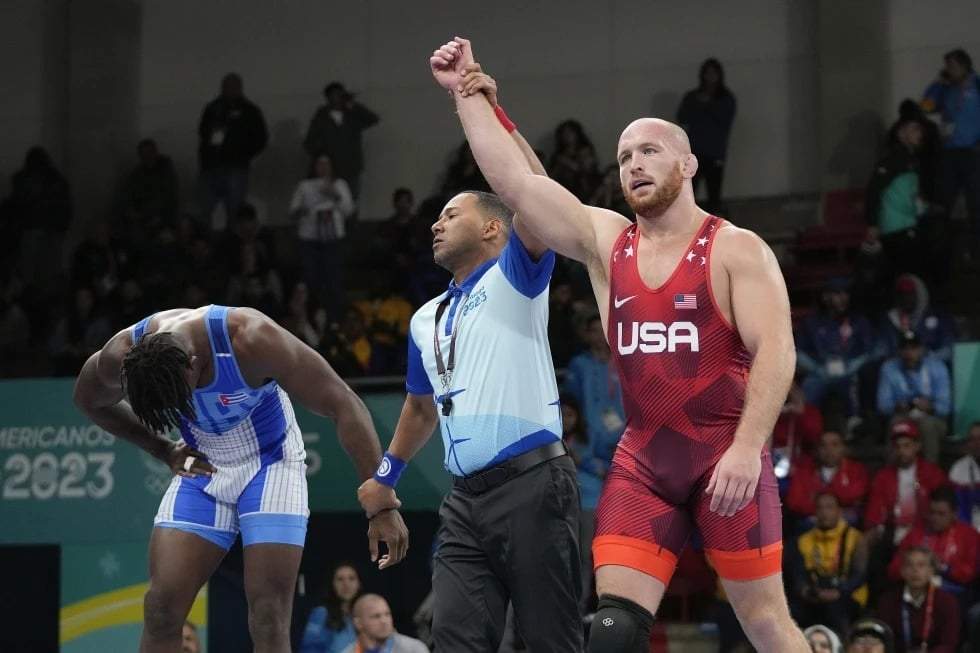 El estadounidense Kyle Snyder (derecha) celebra tras ganar el oro contra el cubano Arturo Silot (izquierda) durante la final de lucha libre masculina de 97 kg en los Juegos Panamericanos de Santiago, Chile, el 1 de noviembre de 2023.