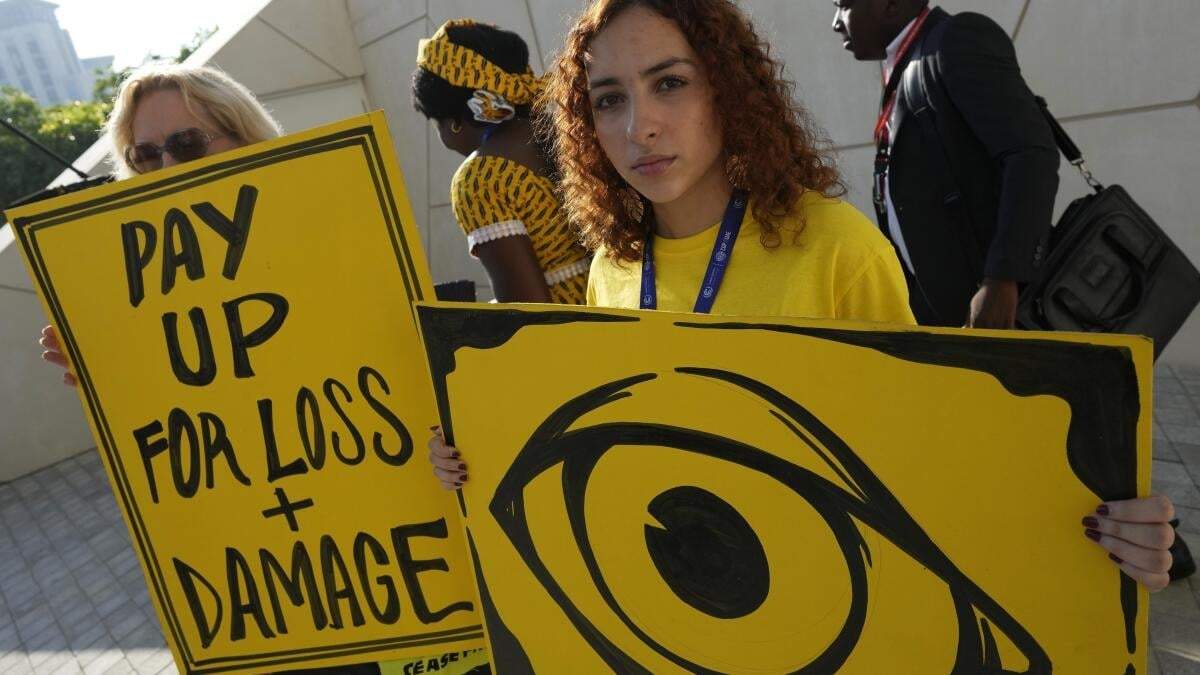 Una persona sostiene un cartel que reclama pagos por pérdidas y daños en la cumbre climática COP28, el lunes 4 de diciembre de 2023 en Dubái, Emiratos Árabes Unidos. El cartel dicen “Paguen por pérdidas + daños”