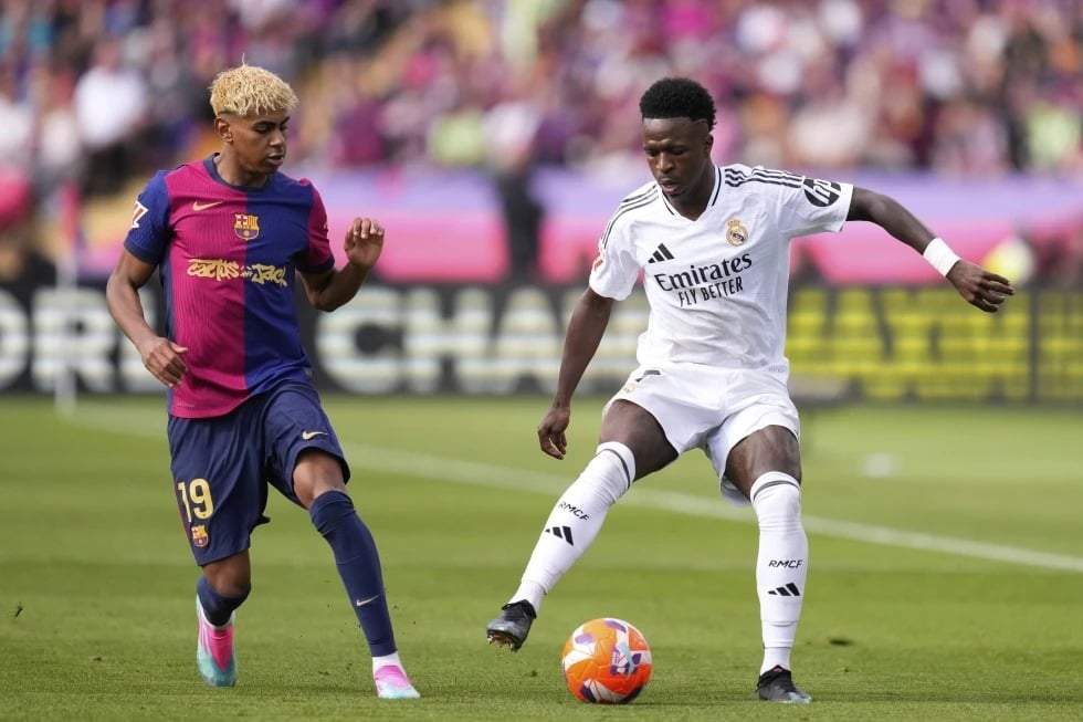 Vinicius Júnior (derecha) del Real Madrid y Lamine Yamal del Barcelona pugnan por el balón en el partido de la Liga española, el domingo 11 de mayo de 2025, en Barcelona.