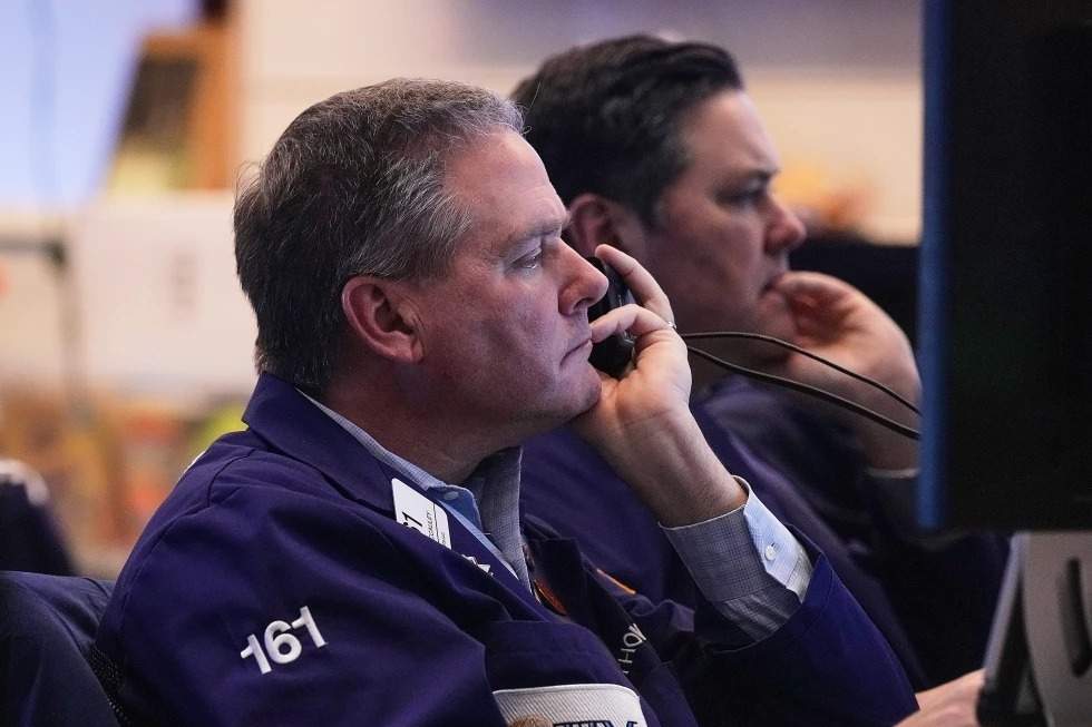El operador Thomas McCauley, en primer plano, y un colega trabajan en el parqué de la Bolsa de Valores de Nueva York, el viernes 2 de enero de 2026.