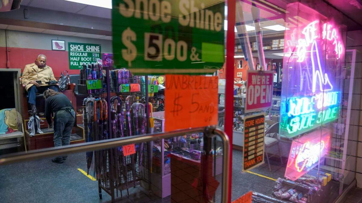 Un cliente se sienta para que le limpien los zapatos en un taller de reparación de calzado el 3 de febrero de 2023, en Nueva York