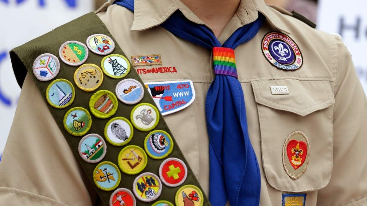 Insignias de mérito y un pañuelo con los colores del arcoíris en el uniforme de un niño explorador afuera de la sede de Amazon, en Seattle
