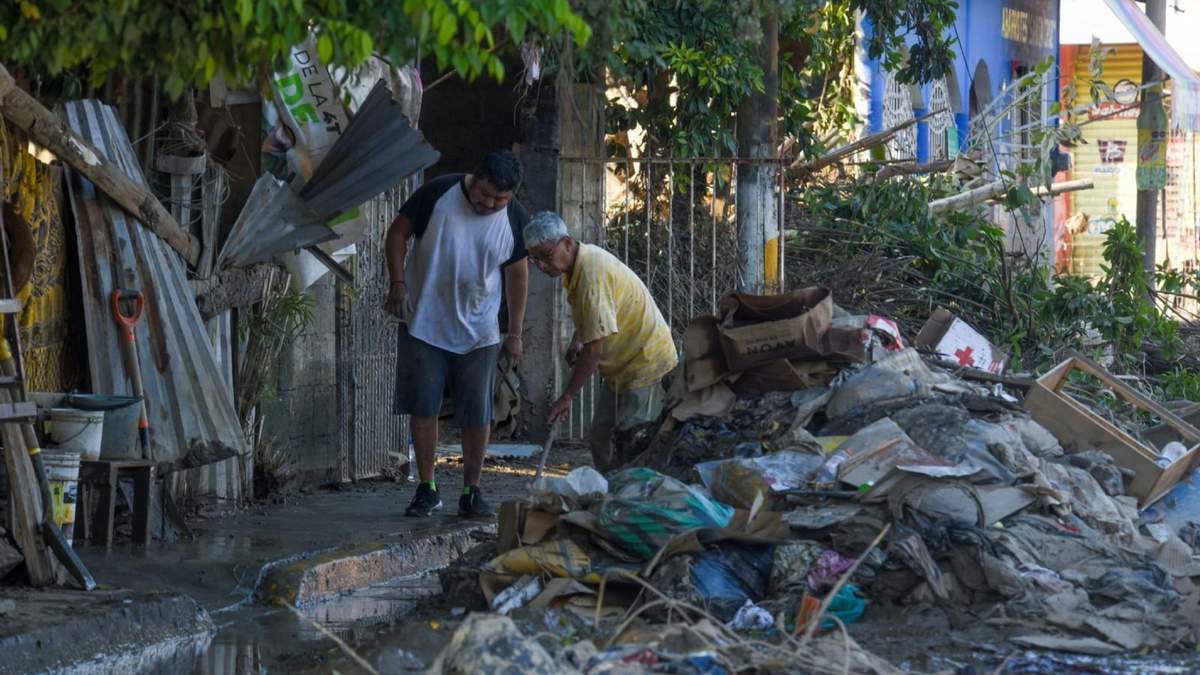 Dos hombres apilan escombros en la calle en el municipio de Álamo continúan en donde se continua con los trabajos de limpieza en las comunidades, las cuales se vieron afectadas por las lluvias en Álamo, Veracruz