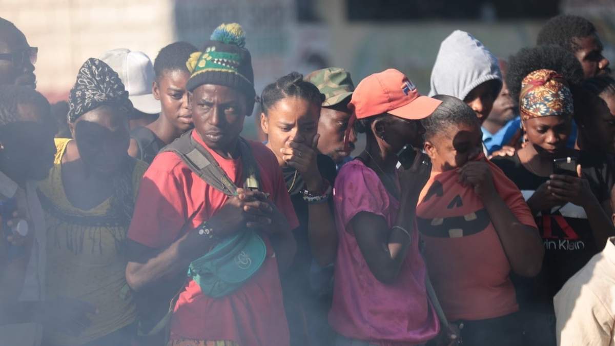 Personas observan los cadáveres de presuntos pandilleros que fueron quemados vivos en Puerto Príncipe