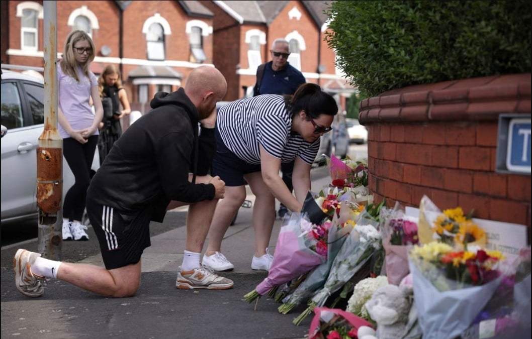 Gente deja flores cerca del lugar en Hart Street donde murieron dos niñas y nueve resultaron heridos en un ataque con arma blanca durante una clase de danza en Southport, Inglaterra