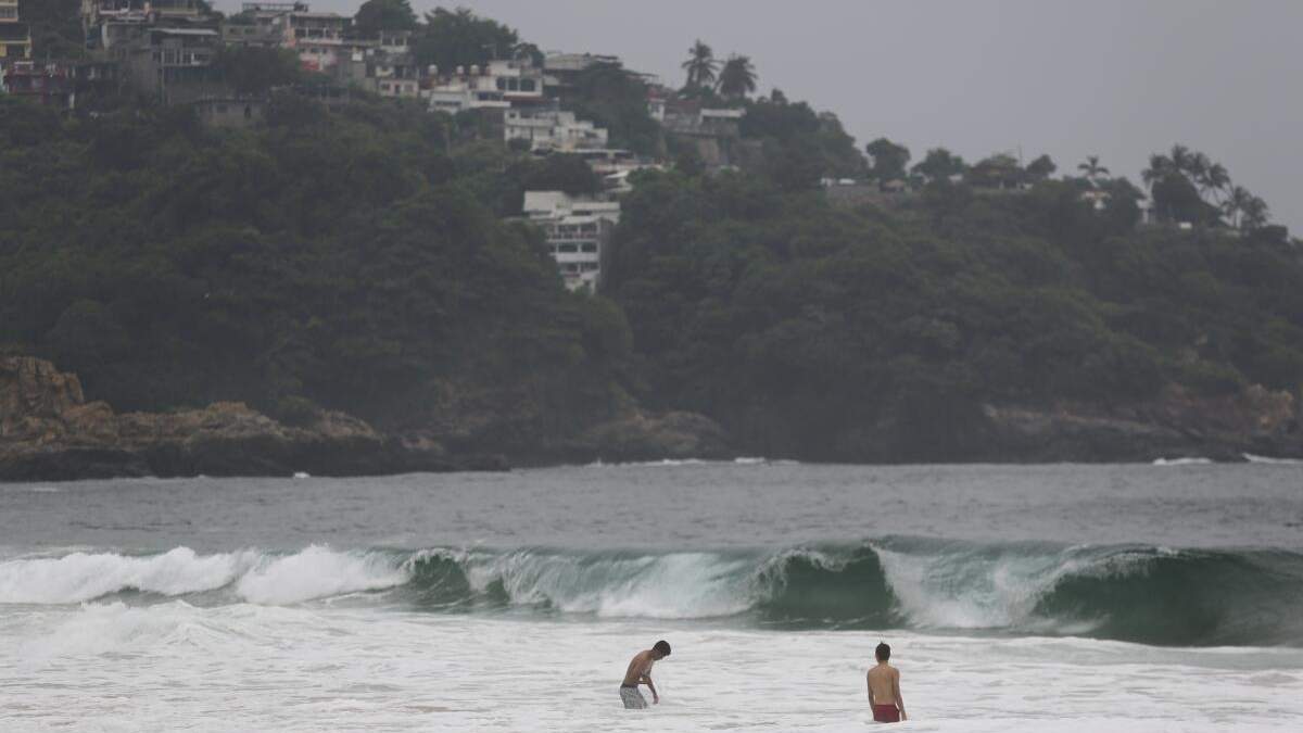 Turistas nadan en Acapulco, México, el 24 de octubre de 2023, antes de la llegada del huracán Otis