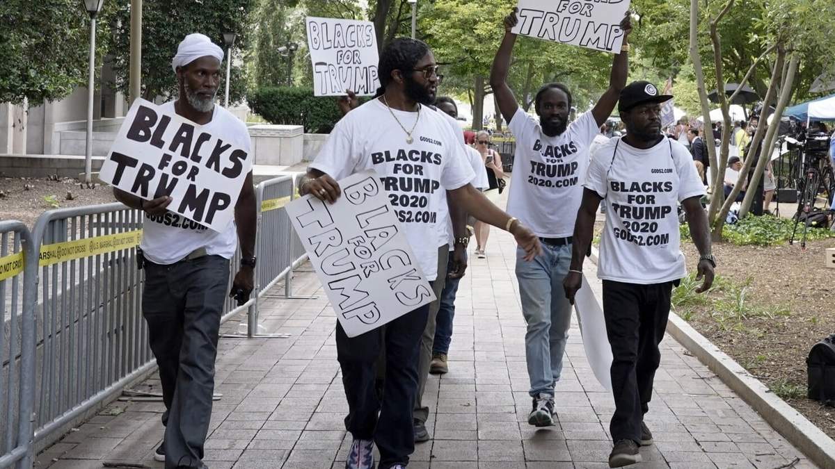 ARCHIVO - Simpatizantes del expresidente Donald Trump con carteles y camisetas en las que se lee «Negros por Trump» se reúnen cerca de la Corte Federal de Estados Unidos E. Barrett Prettyman, el 3 de agosto de 2023, en Washington. ()