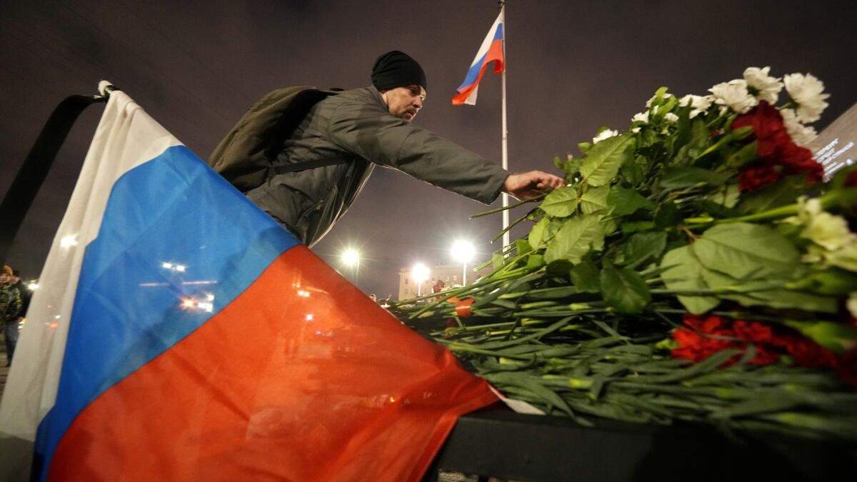 Un hombre coloca flores en un altar improvisado a las víctimas del ataque en Moscú, en San Petersburgo, Rusia,