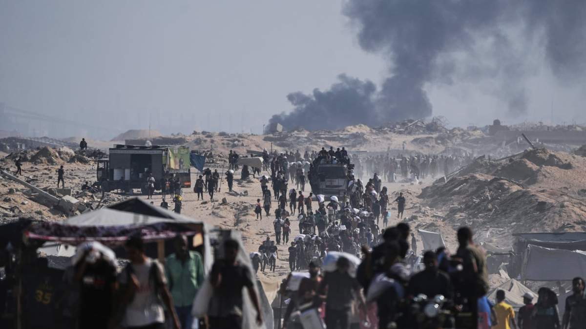 Palestinos cargan sacos de harina descargados de un convoy de ayuda humanitaria en las afueras de Beit Lahiya, en el norte de la Franja de Gaza